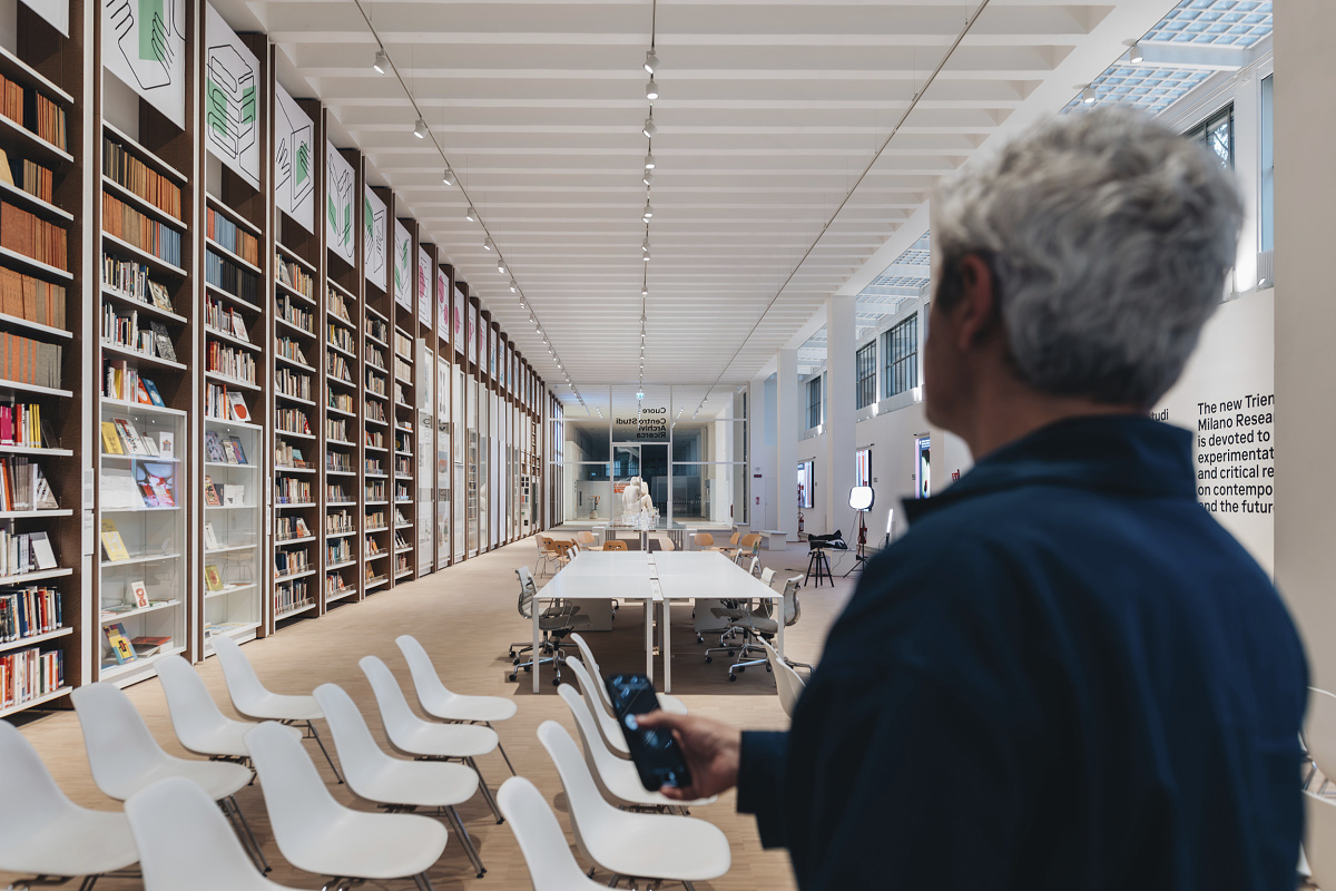 Triennale Museum interior featuring Hi-trac track spotlights and bookshelves.