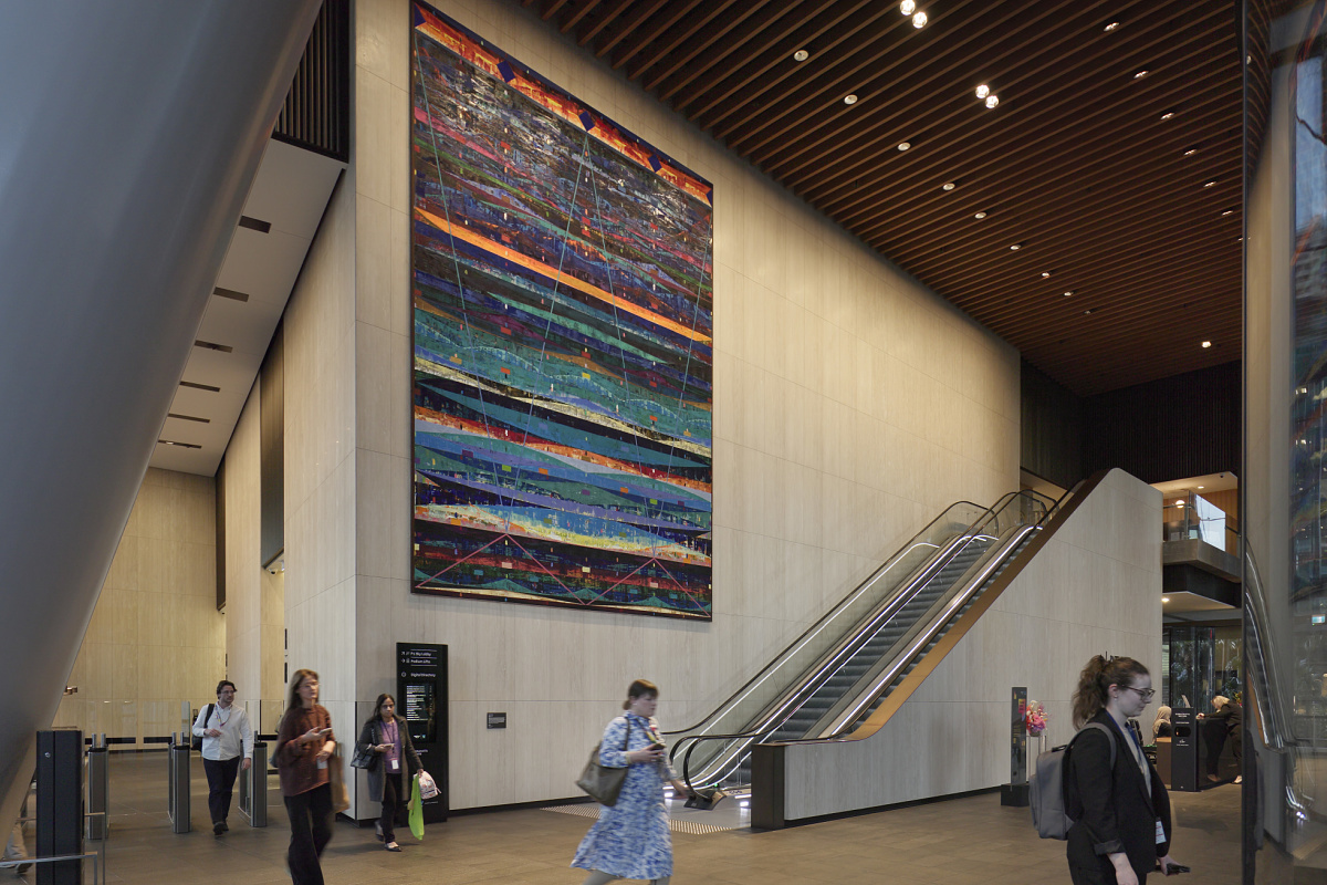 Parramatta Square lobby featuring art and escalator, illuminated by ERCO lighting.