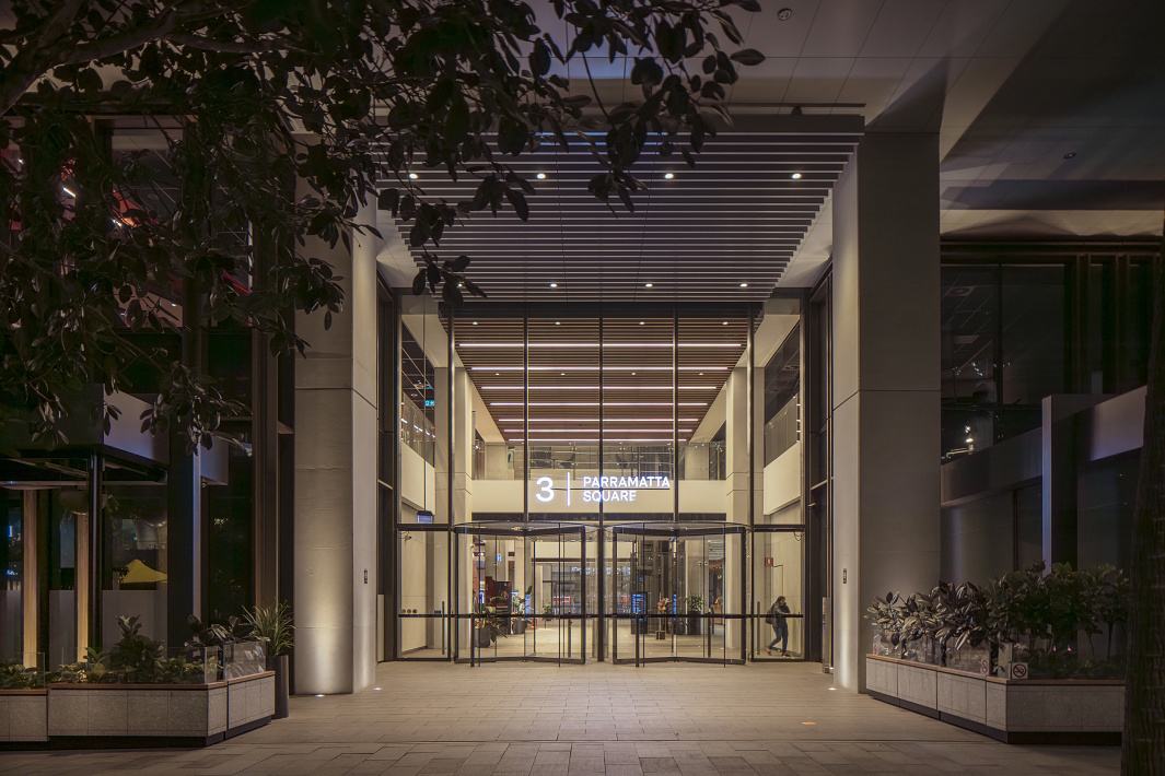 Entrance to 3 Parramatta Square office building with inviting lighting in Sydney, Australia.