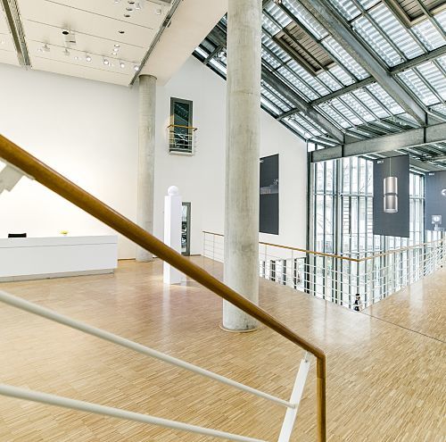 ERCO building interior featuring stairs, columns, and skylight for natural lighting.