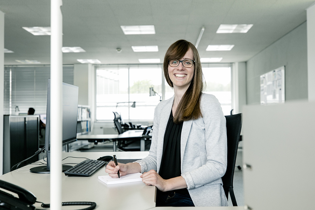 ERCO employee at her desk, working in the office with ERCO lighting.