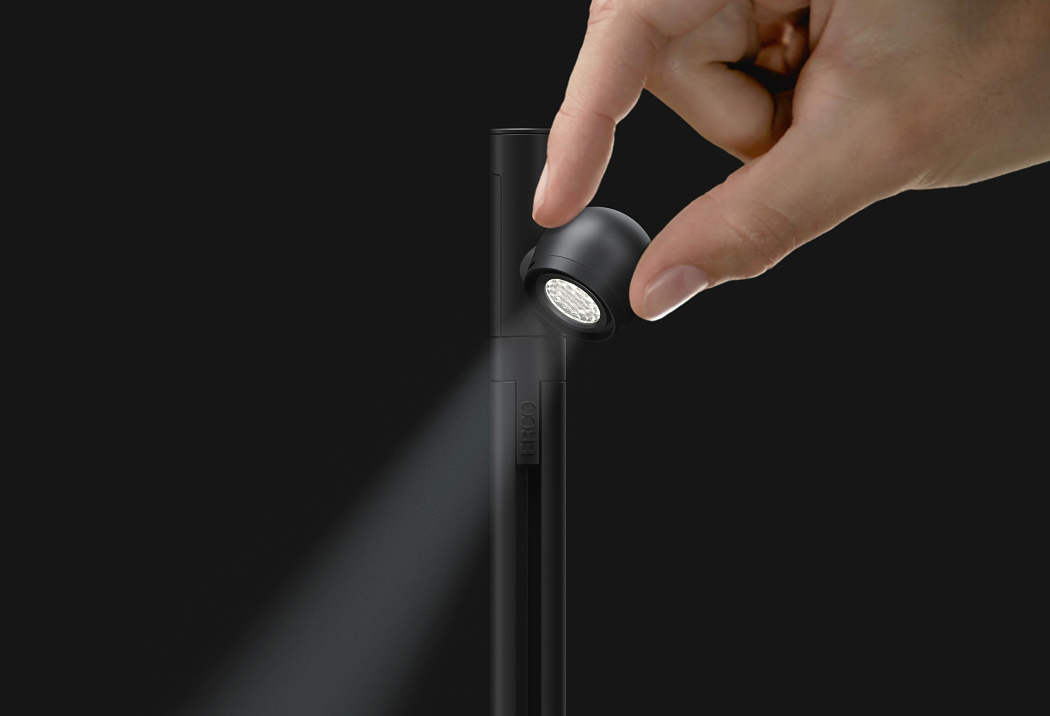 ERCO Axis LED spotlight for museum showcase lighting, being adjusted by hand.