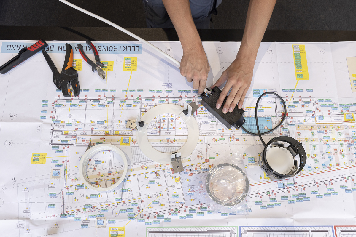 Installing ERCO LED downlights on a blueprint for Sparkasse Ulm.