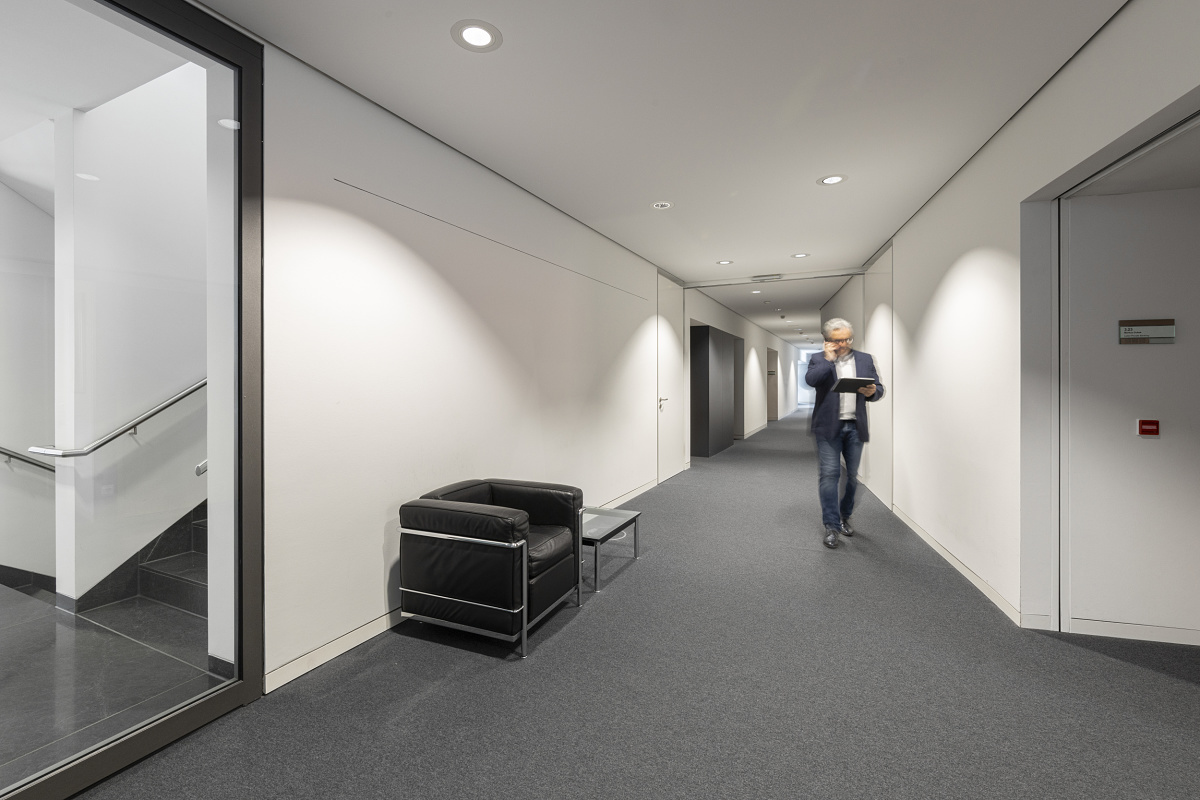 ERCO Quintessence LED downlights illuminate a Sparkasse Ulm hallway efficiently.