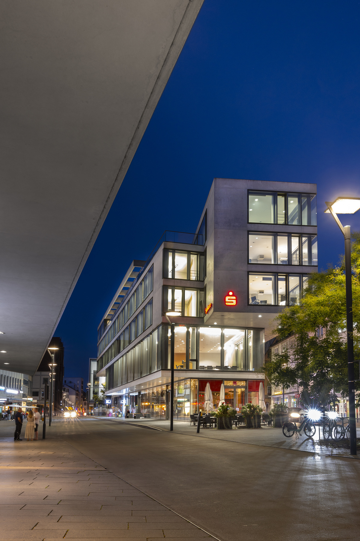Sparkasse Ulm at night, illuminated by ERCO LED downlights for improved energy efficiency and light quality.