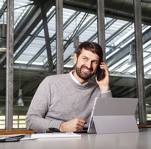 ERCO employee talking on the phone while working on a laptop.