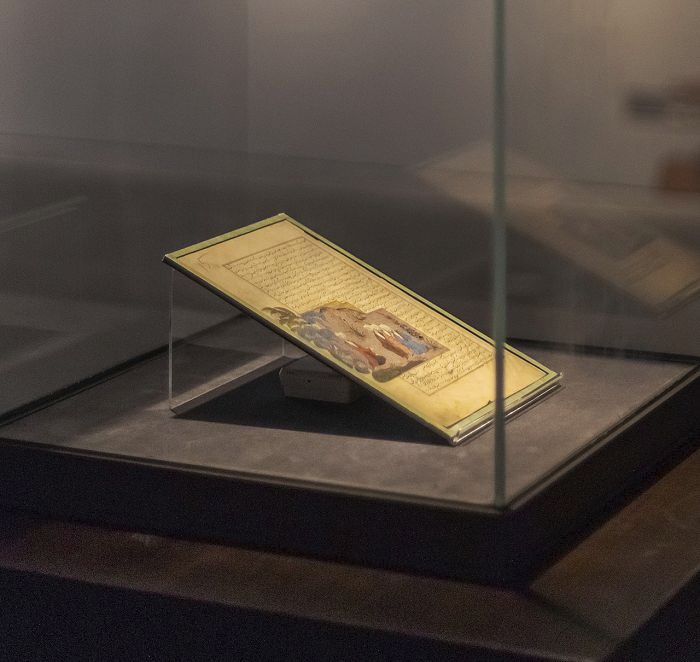 Illuminated miniature painting under ERCO lighting in a museum display case.
