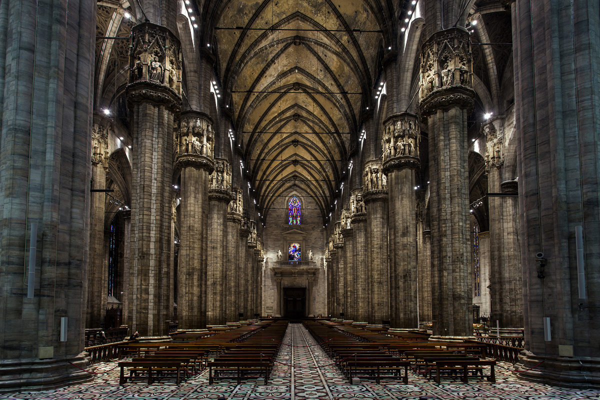 Interior of Milan Cathedral featuring tall columns and vaulted ceiling, illuminated with ERCO lighting.