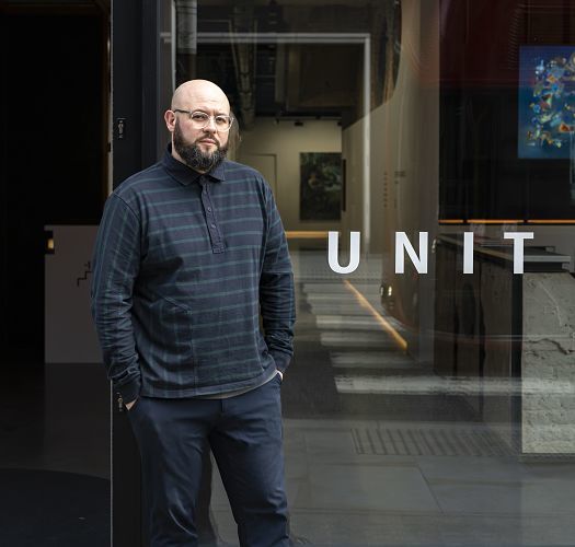 Sebastian Humphrys, Exhibitions Manager at Unit London, stands in front of the gallery.