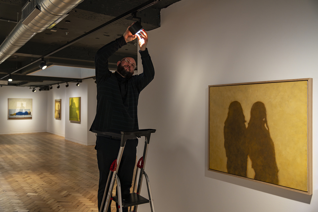ERCO LED spotlight being adjusted to illuminate artwork in Unit Gallery.