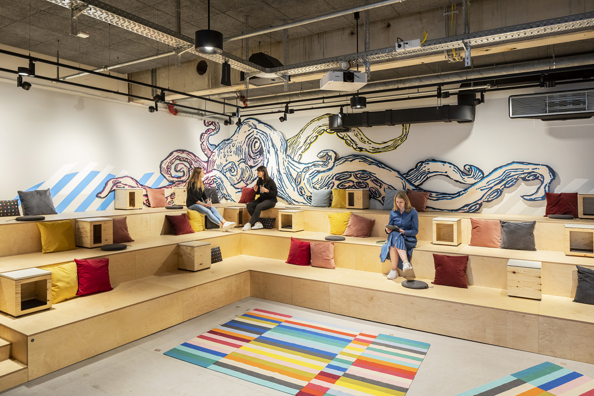 People sit in an office space with ERCO luminaires, creating a comfortable atmosphere.
