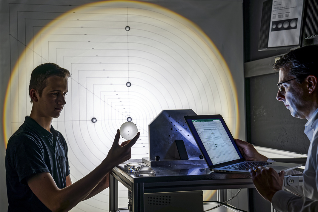 ERCO employees planning light, using a sphere to analyze light distribution.