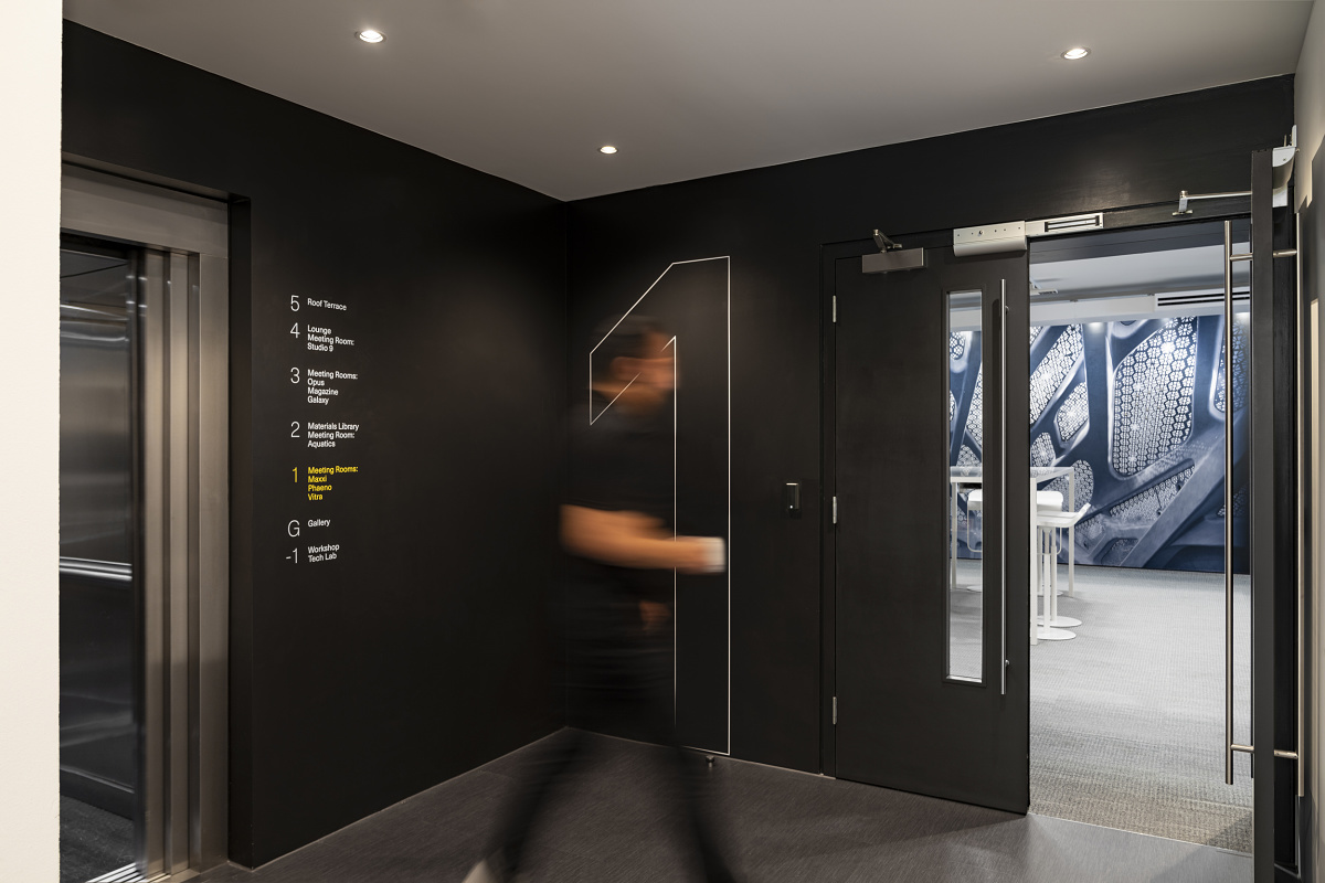 ERCO lighting at Zaha Hadid London: Hallway with directory to meeting rooms and elevator.