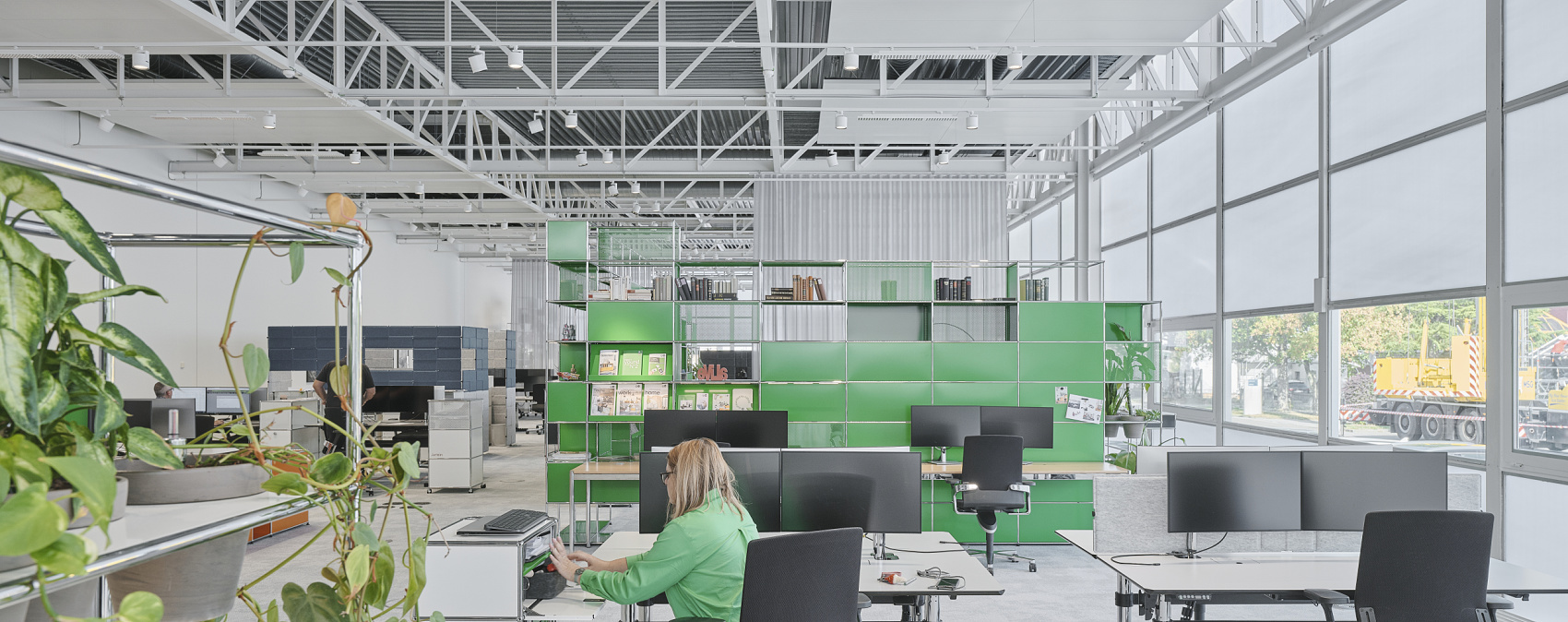 Flexible ERCO lighting design in the USM Show Office with Jilly downlights and Parscan spotlights for adaptable office lighting.
